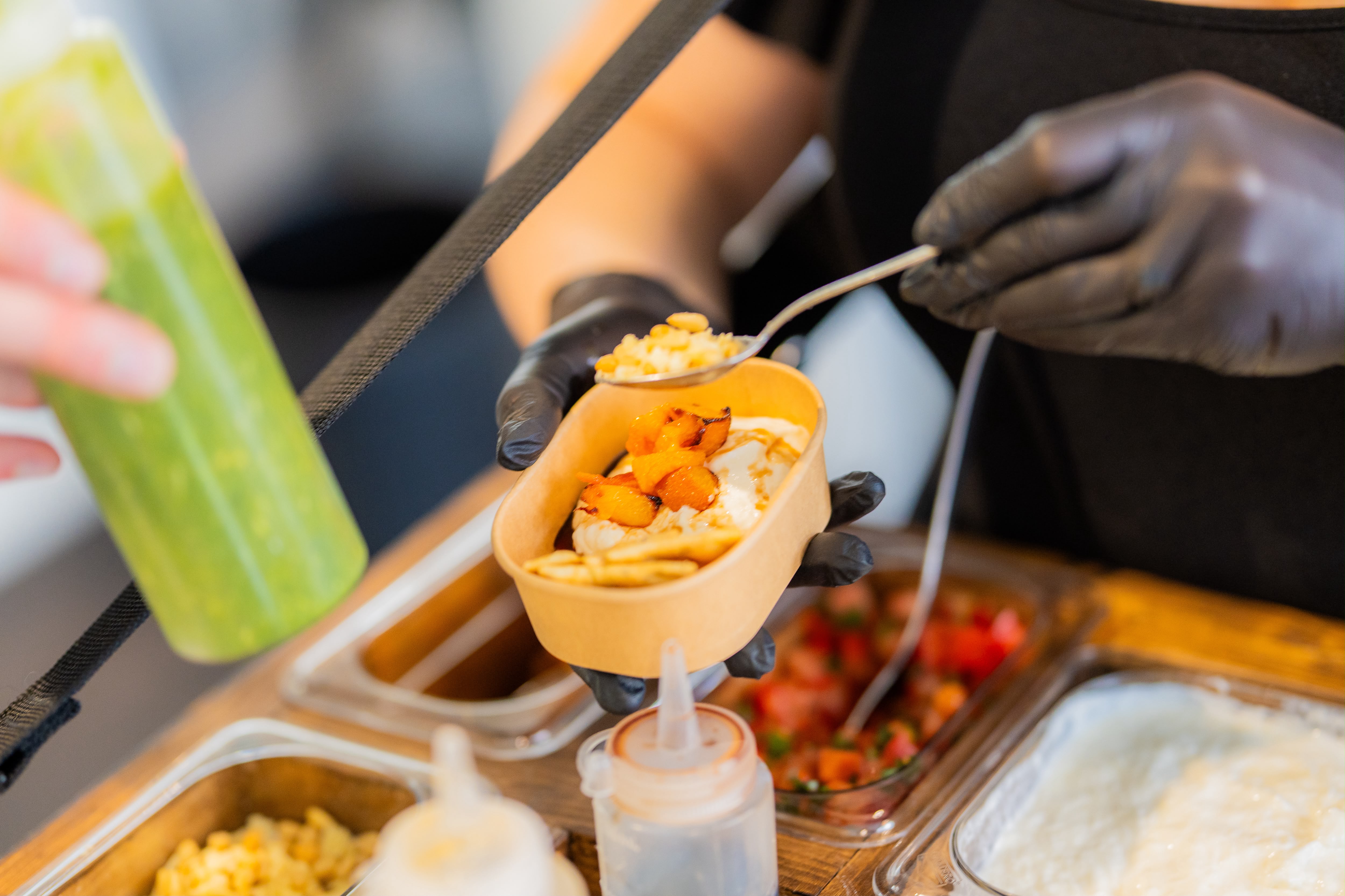 Een verse burrata-bowl wordt live opgebouwd met toppings en saus tussen de gasten