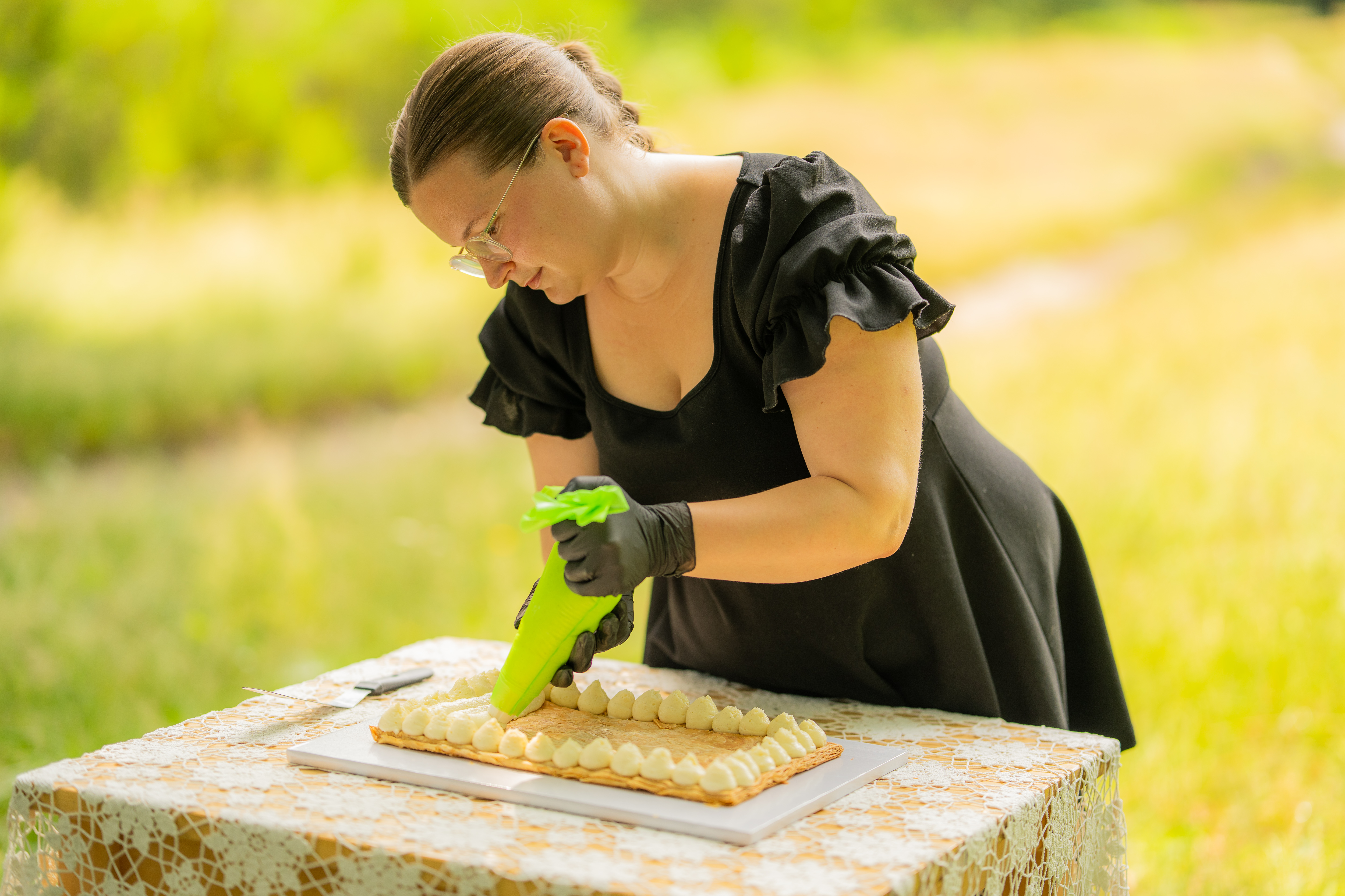 Charlotte van Hangende Hapjes spuit verse Zwitserse room op een Italiaanse millefoglie bruidstaart op locatie