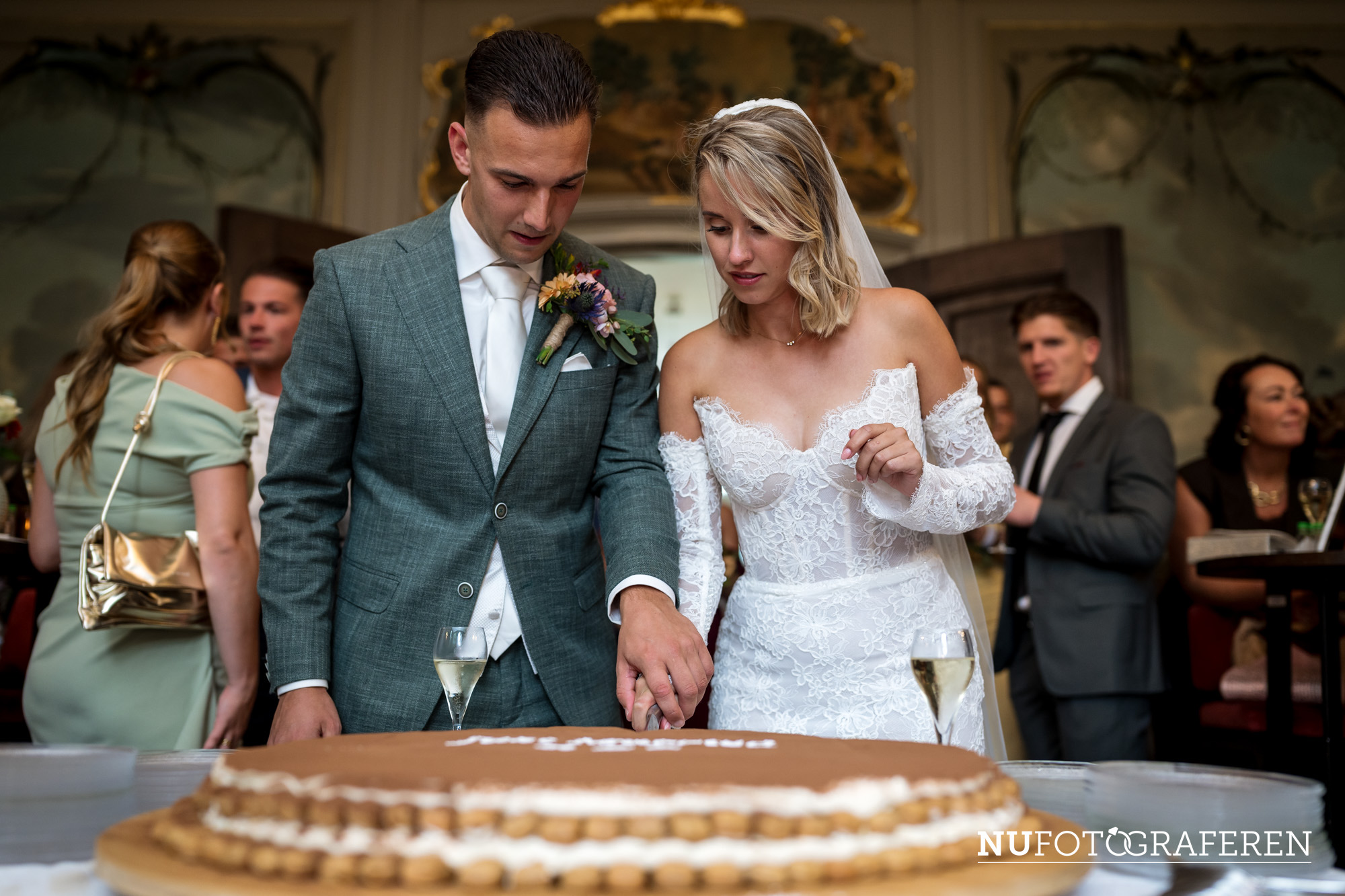 Bruidspaar snijdt samen een grote tiramisutaart aan