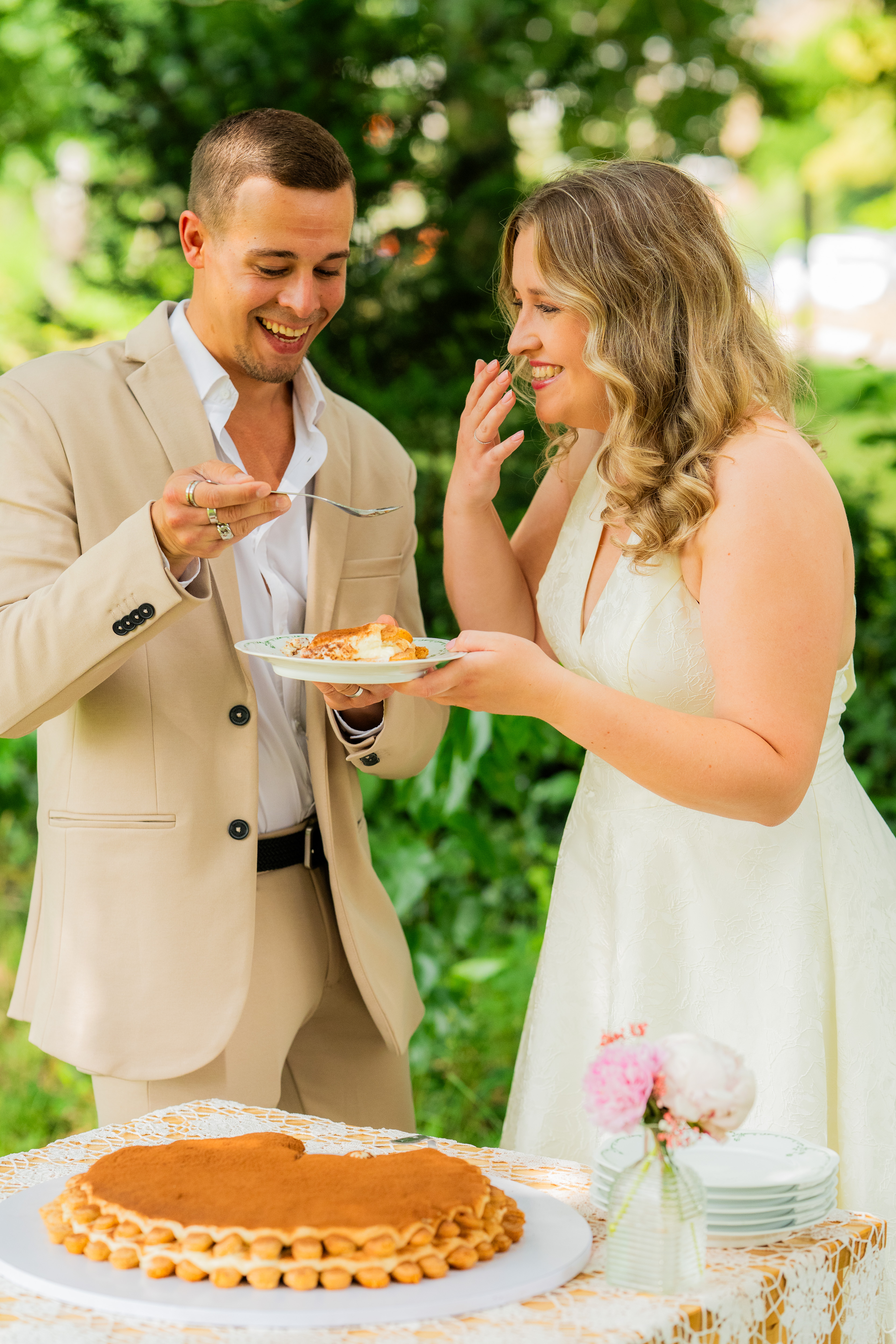 Bruidegom geeft de bruid een hapje van de verse tiramisu taart